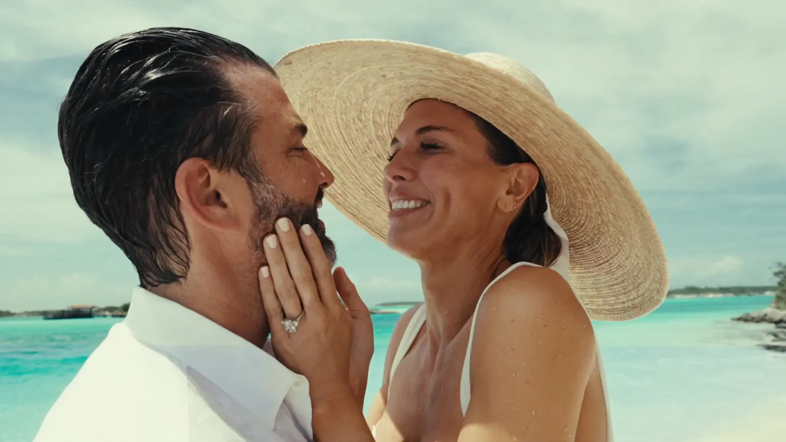 Bettina in a straw hat, hands on his face