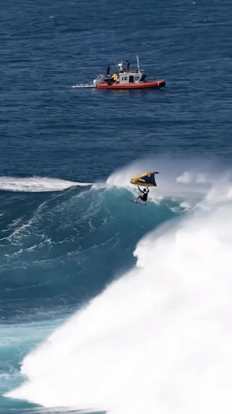 Kai Lenny surfing like a pelican over Jaws, on his feed
